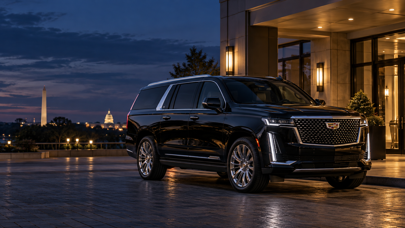 Black Cadillac Escalade ESV outside a modern hotel at dusk